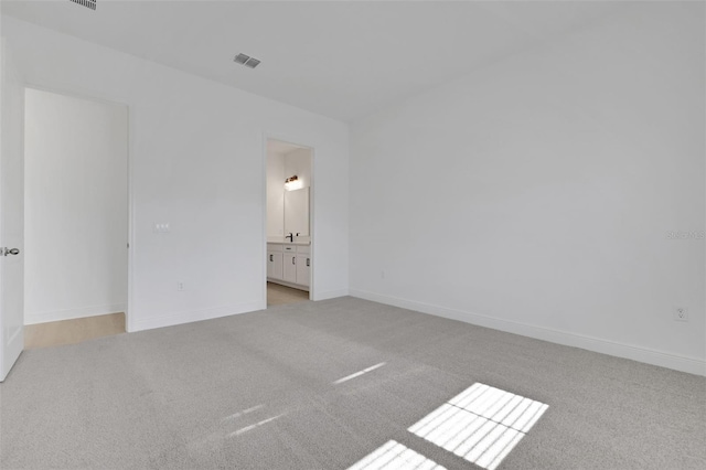 empty room featuring baseboards, visible vents, and carpet floors