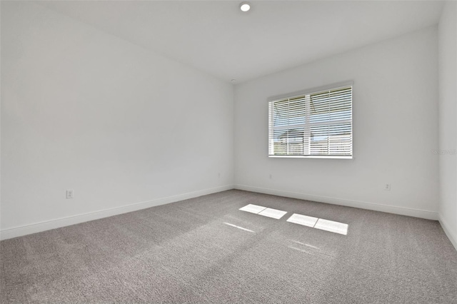 carpeted spare room with baseboards