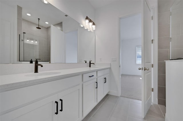 bathroom featuring tile patterned flooring, double vanity, a walk in shower, and a sink