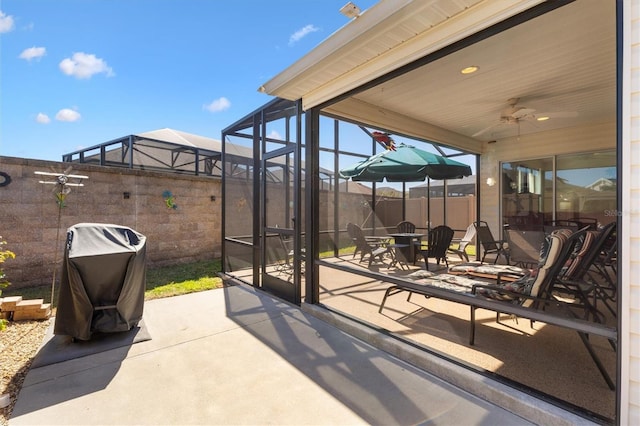 5829 Tupelo Ter, The Villages, FL 32163 - view of patio featuring ceiling fan, glass enclosure, a grill, outdoor dining area, and fence