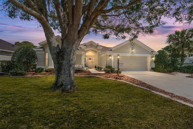 view of front of property with an attached garage, driveway, stucco siding, and a front yard