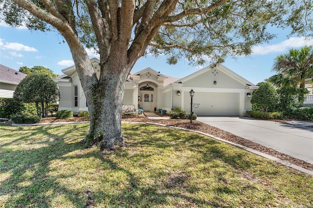 view of front of home featuring a garage, a front yard, driveway, and stucco siding