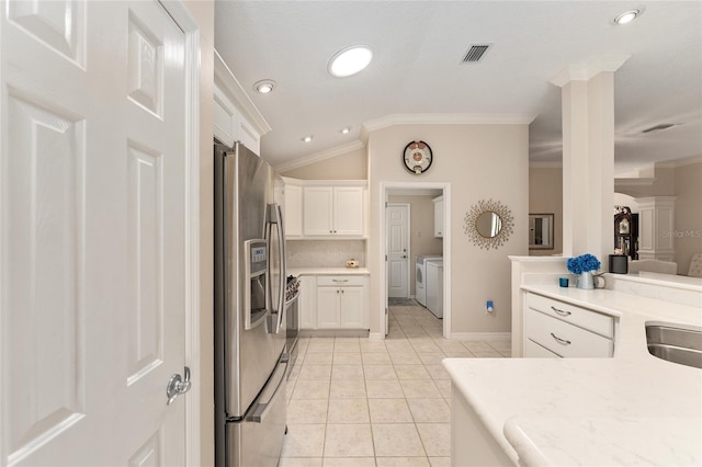 kitchen with stainless steel fridge with ice dispenser, visible vents, crown molding, independent washer and dryer, and lofted ceiling