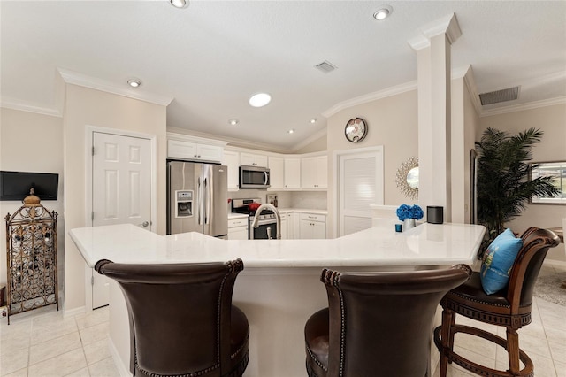 kitchen featuring light tile patterned floors, white cabinets, vaulted ceiling, visible vents, and appliances with stainless steel finishes
