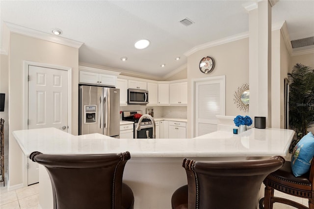 kitchen with a kitchen bar, crown molding, lofted ceiling, and stainless steel appliances
