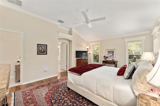 bedroom featuring ensuite bath, visible vents, ornamental molding, and wood finished floors