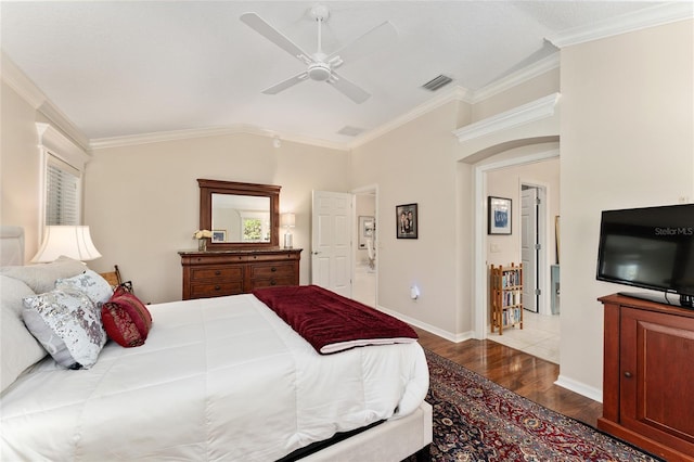 bedroom featuring dark wood-type flooring, crown molding, lofted ceiling, and visible vents