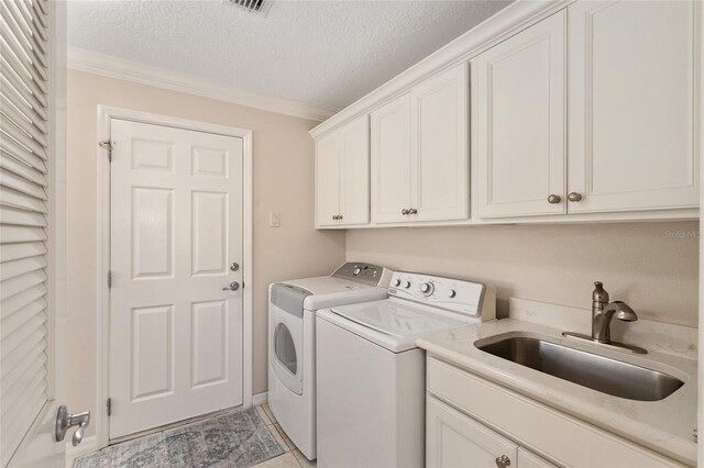 clothes washing area featuring separate washer and dryer, a sink, a textured ceiling, crown molding, and cabinet space