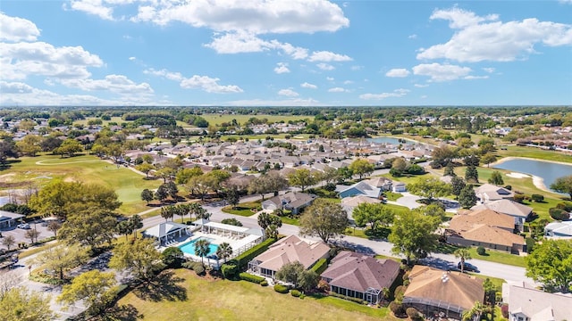 drone / aerial view featuring view of golf course, a residential view, and a water view