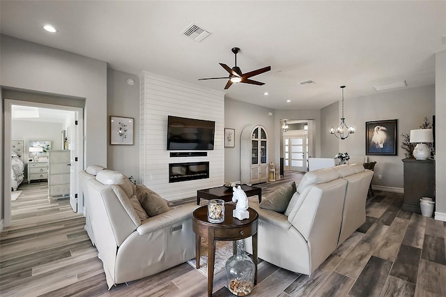 5557 Hawkins Dr, The Villages, FL 32163 - living area with wood finished floors, recessed lighting, ceiling fan with notable chandelier, and visible vents