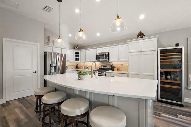 5557 Hawkins Dr, The Villages, FL 32163 - kitchen with light countertops, decorative backsplash, beverage cooler, visible vents, and appliances with stainless steel finishes