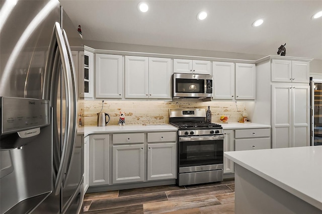 5557 Hawkins Dr, The Villages, FL 32163 - kitchen with light countertops, wood finish floors, tasteful backsplash, and appliances with stainless steel finishes