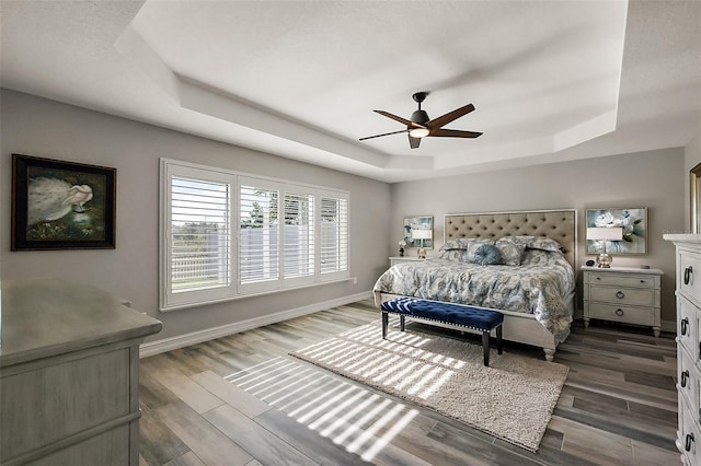 5557 Hawkins Dr, The Villages, FL 32163 - bedroom with baseboards, wood finished floors, and a raised ceiling