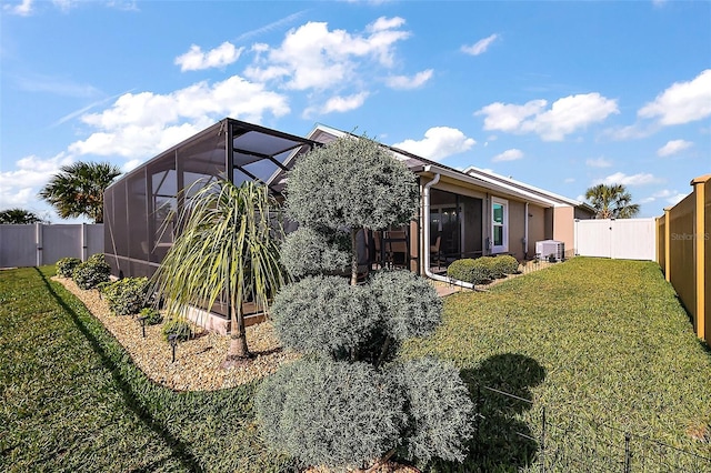 5557 Hawkins Dr, The Villages, FL 32163 - rear view of property featuring a lanai, a fenced backyard, and a yard