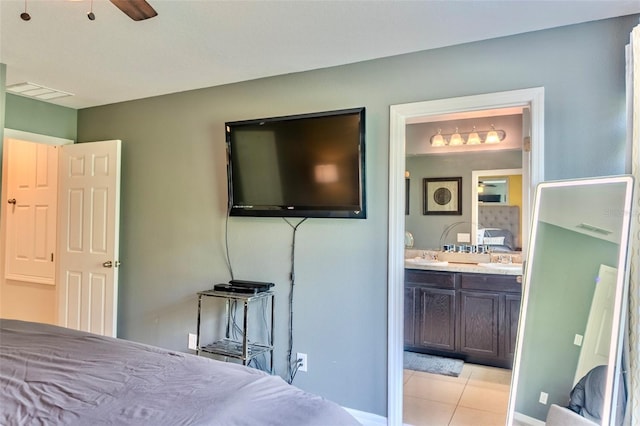 144 Primrose Dr, Davenport, FL 33837 - bedroom with light tile patterned flooring, ensuite bath, visible vents, and a sink