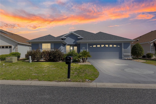 ranch-style home featuring driveway, an attached garage, stucco siding, and a front yard
