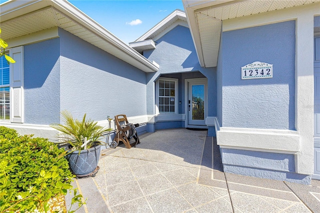 property entrance with stucco siding