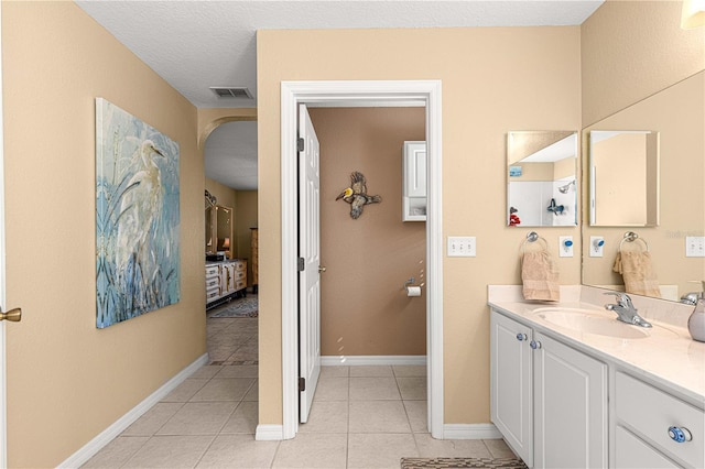 full bathroom with baseboards, visible vents, tile patterned floors, and vanity