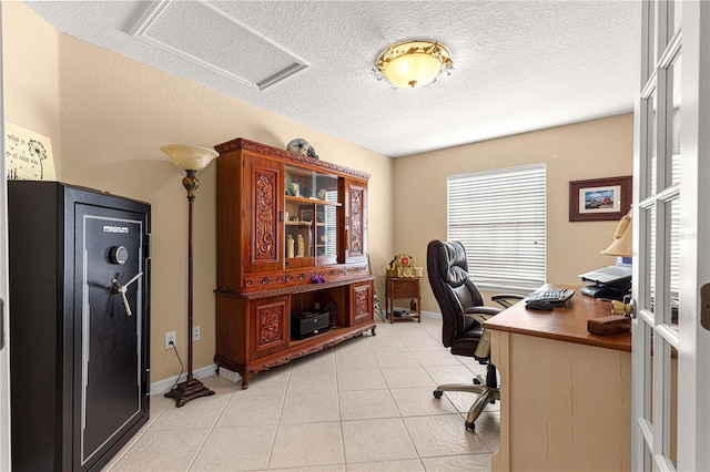 home office featuring light tile patterned flooring, a textured ceiling, visible vents, baseboards, and attic access