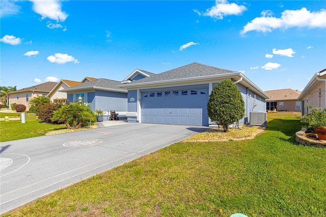 ranch-style house featuring concrete driveway, central air condition unit, stucco siding, an attached garage, and a front lawn