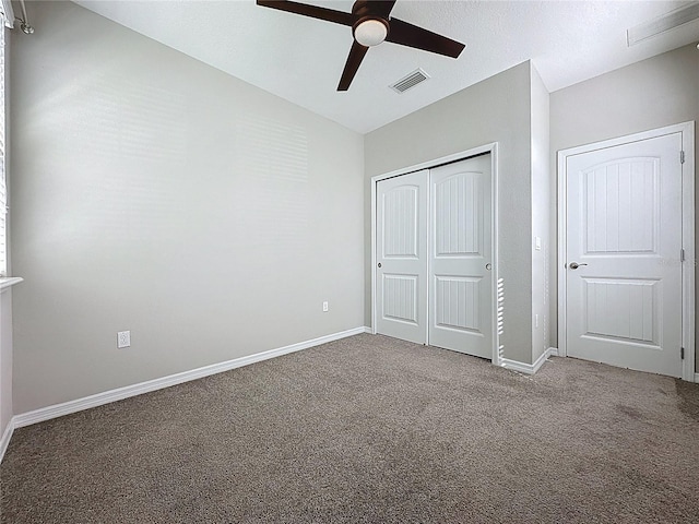unfurnished bedroom with visible vents, carpet floors, a closet, baseboards, and ceiling fan
