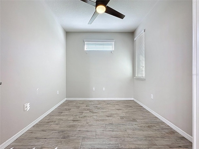 spare room with baseboards, wood finish floors, a textured ceiling, and ceiling fan