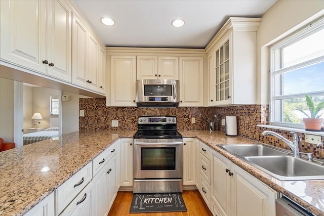 29051 Magnolia Ln, Big Pine Key, FL 33043 - kitchen featuring a sink, appliances with stainless steel finishes, light wood-style floors, and decorative backsplash