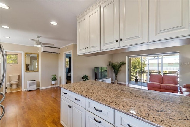 29051 Magnolia Ln, Big Pine Key, FL 33043 - kitchen with white cabinets, a wall unit AC, a ceiling fan, and light wood finished floors