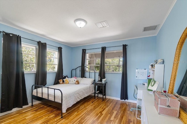 29051 Magnolia Ln, Big Pine Key, FL 33043 - bedroom featuring a textured ceiling, visible vents, light wood-style floors, and crown molding