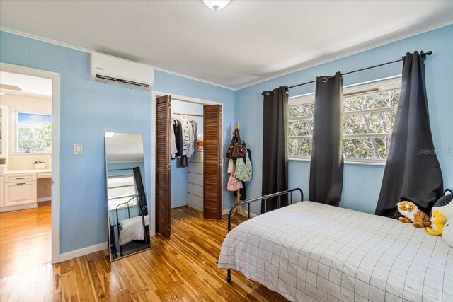 29051 Magnolia Ln, Big Pine Key, FL 33043 - bedroom featuring light wood finished floors, a closet, a wall mounted AC, and crown molding