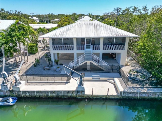 29051 Magnolia Ln, Big Pine Key, FL 33043 - rear view of house featuring stairs, a patio area, a sunroom, fence private yard, and a water view