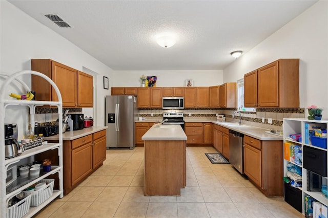 kitchen featuring tasteful backsplash, visible vents, stainless steel appliances, and a sink