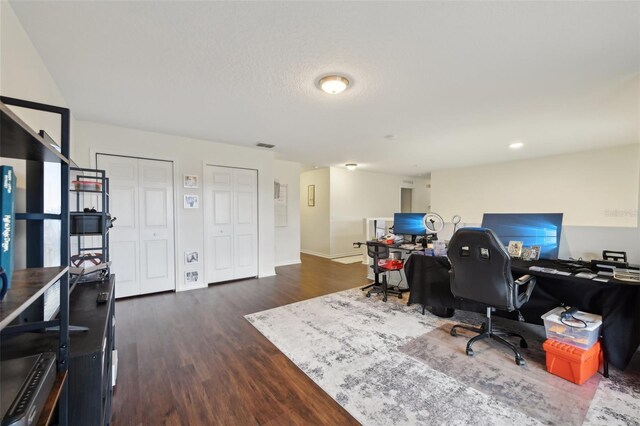 home office featuring visible vents, dark wood-style flooring, and baseboards