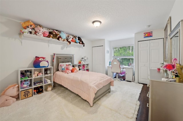 bedroom with a textured ceiling and two closets