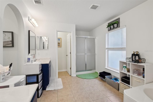 bathroom with a stall shower, visible vents, vanity, and baseboards