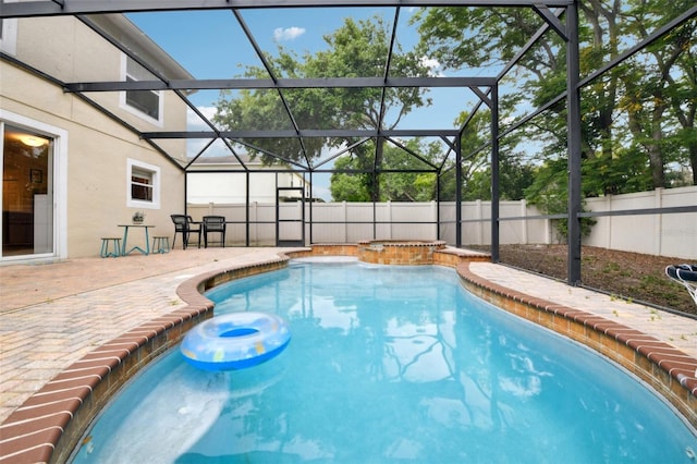 view of pool featuring a patio, an in ground hot tub, a fenced in pool, glass enclosure, and a fenced backyard