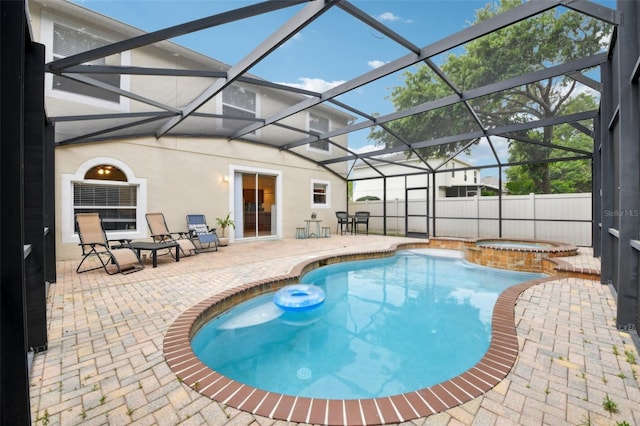 view of swimming pool with a pool with connected hot tub, a lanai, a patio, and a fenced backyard