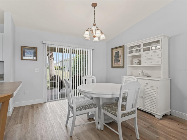 2111 Harston Trl, The Villages, FL 32162 - dining space featuring an inviting chandelier, baseboards, vaulted ceiling, and light wood-type flooring