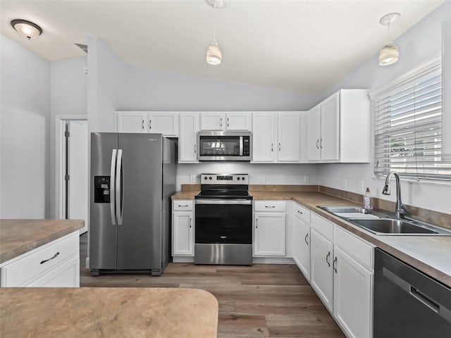 2111 Harston Trl, The Villages, FL 32162 - kitchen with lofted ceiling, a sink, white cabinets, appliances with stainless steel finishes, and wood finished floors