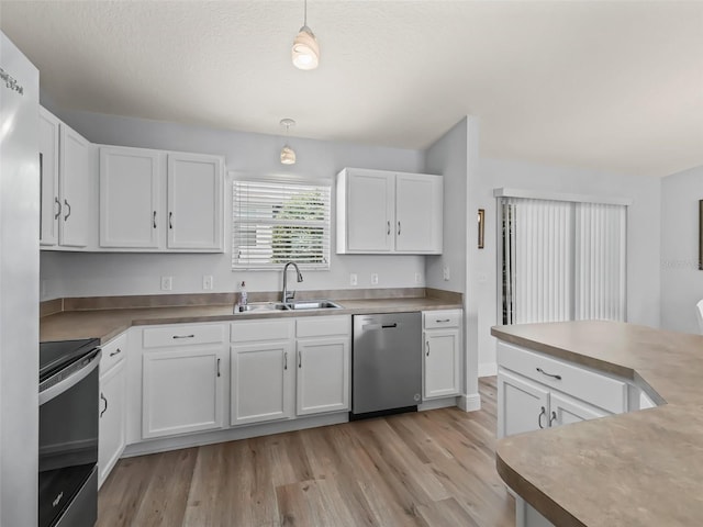 2111 Harston Trl, The Villages, FL 32162 - kitchen featuring white cabinetry, a sink, stainless steel appliances, and light wood finished floors