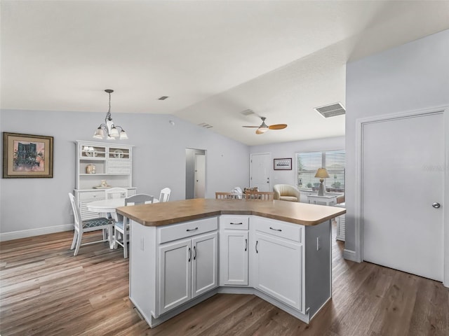 2111 Harston Trl, The Villages, FL 32162 - kitchen featuring lofted ceiling, ceiling fan with notable chandelier, a kitchen island, visible vents, and wood finished floors