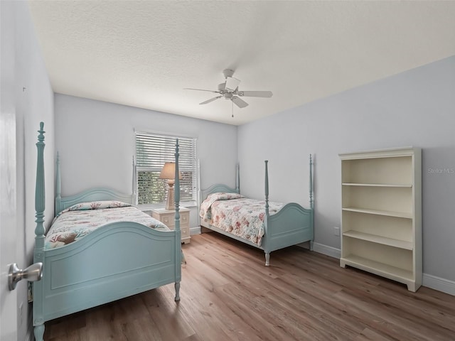 2111 Harston Trl, The Villages, FL 32162 - bedroom featuring baseboards, wood finished floors, ceiling fan, and a textured ceiling
