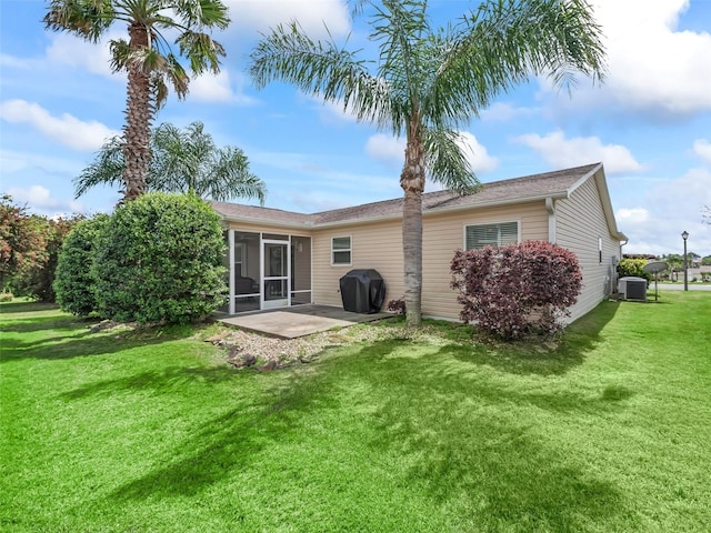 2111 Harston Trl, The Villages, FL 32162 - rear view of house with a sunroom, central air condition unit, a yard, and a patio