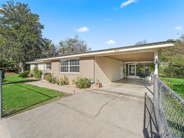 2376 Crk 444, Lake Panasoffkee, FL 33538 - single story home with concrete driveway, fence, a front lawn, brick siding, and an attached carport