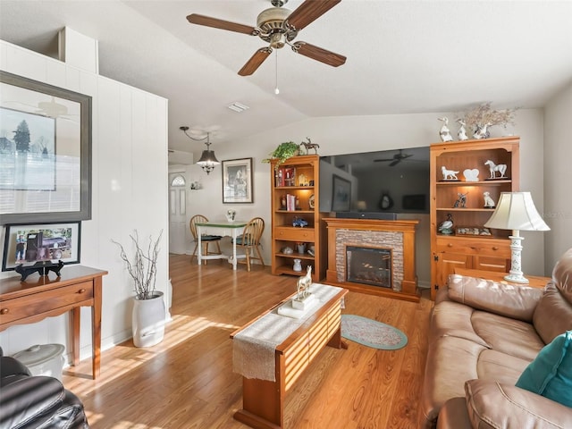2376 Crk 444, Lake Panasoffkee, FL 33538 - living room with visible vents, wood finished floors, a ceiling fan, a stone fireplace, and lofted ceiling