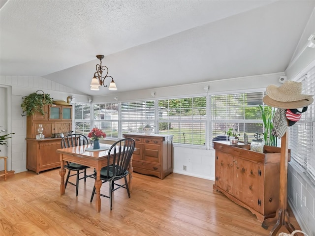 2376 Crk 444, Lake Panasoffkee, FL 33538 - dining space featuring a healthy amount of sunlight, light wood-style flooring, vaulted ceiling, and a chandelier