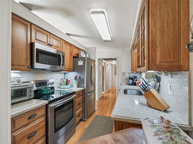 2376 Crk 444, Lake Panasoffkee, FL 33538 - kitchen featuring a sink, stainless steel appliances, and brown cabinetry
