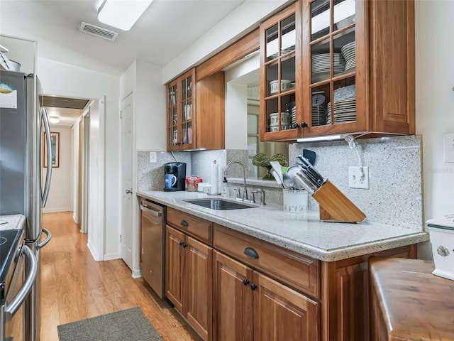 2376 Crk 444, Lake Panasoffkee, FL 33538 - kitchen with visible vents, brown cabinets, appliances with stainless steel finishes, a sink, and light wood-style floors