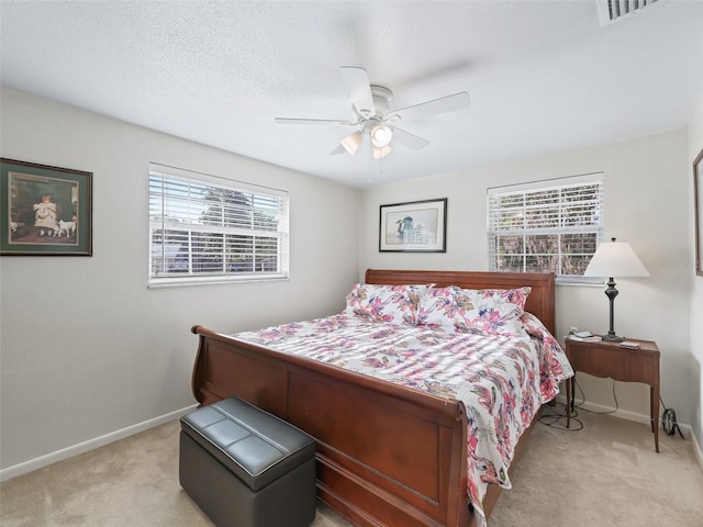 2376 Crk 444, Lake Panasoffkee, FL 33538 - bedroom featuring a textured ceiling, visible vents, baseboards, ceiling fan, and light colored carpet