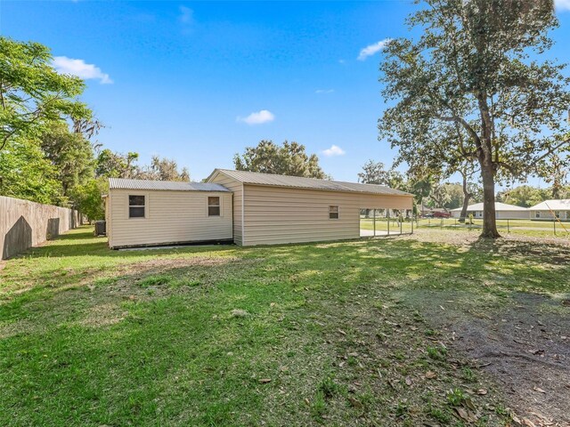 2376 Crk 444, Lake Panasoffkee, FL 33538 - back of house featuring metal roof, fence, and a lawn